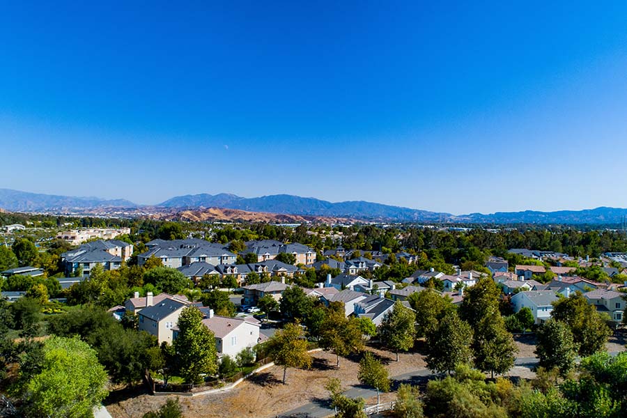 Santa Clarita CA - Aerial View of the Suburbs of Santa Clarita California with Views of Residential Homes Surrounded by Green Trees